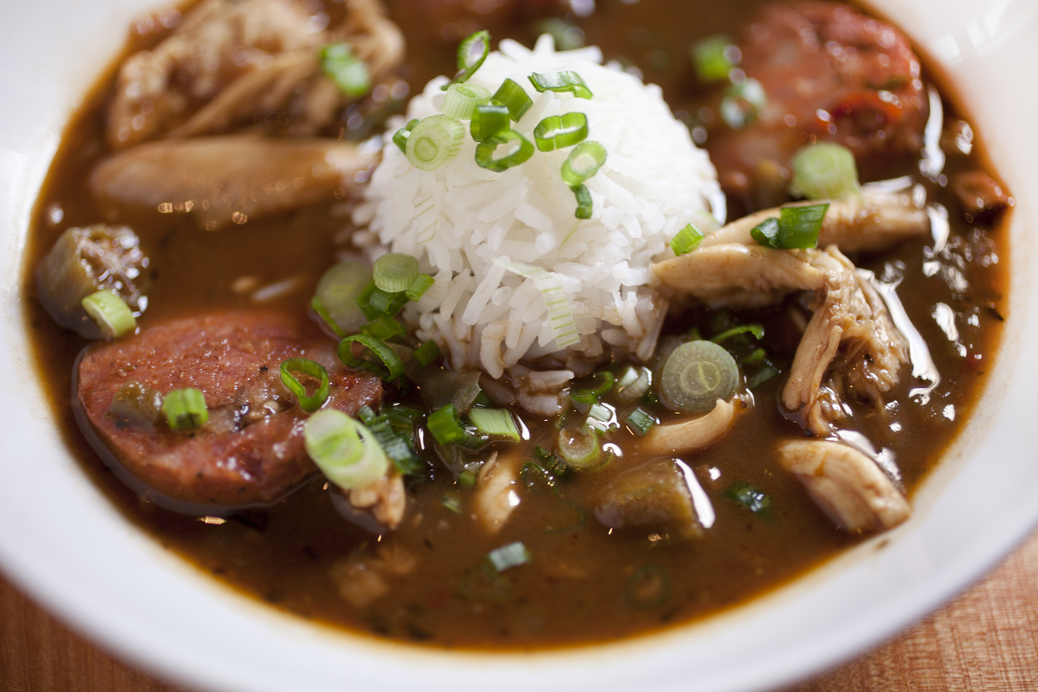 a plate of gumbo with a scoop of rice in the middle