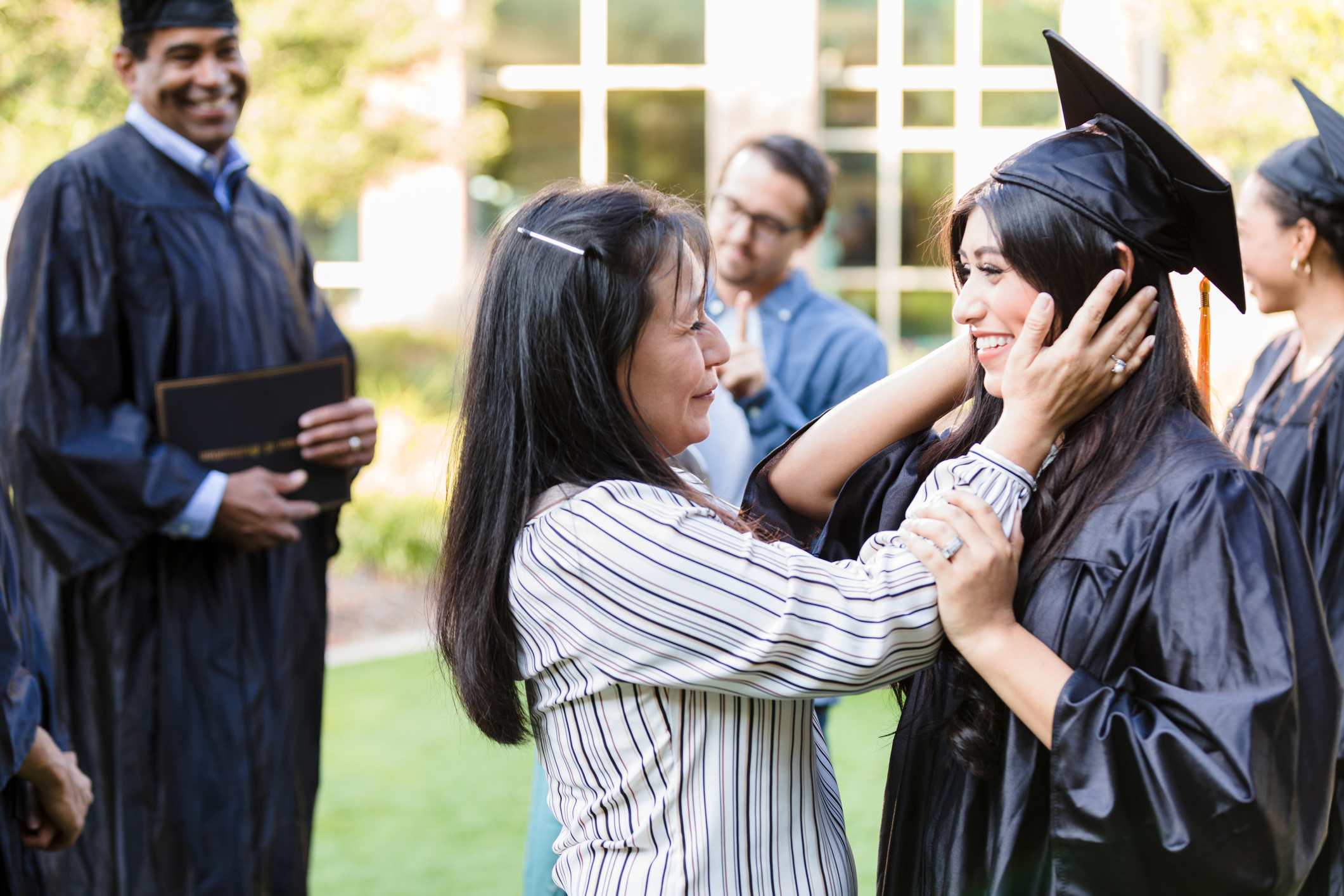A mom is proudly looking at their newly graduated kid
