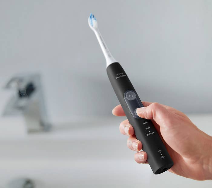 A person holding the toothbrush in black