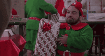 Tony the Elf in Jingle All the Way holding a present and nodding