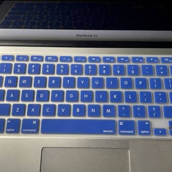 the keyboard cover in blue fully covering a laptop keyboard