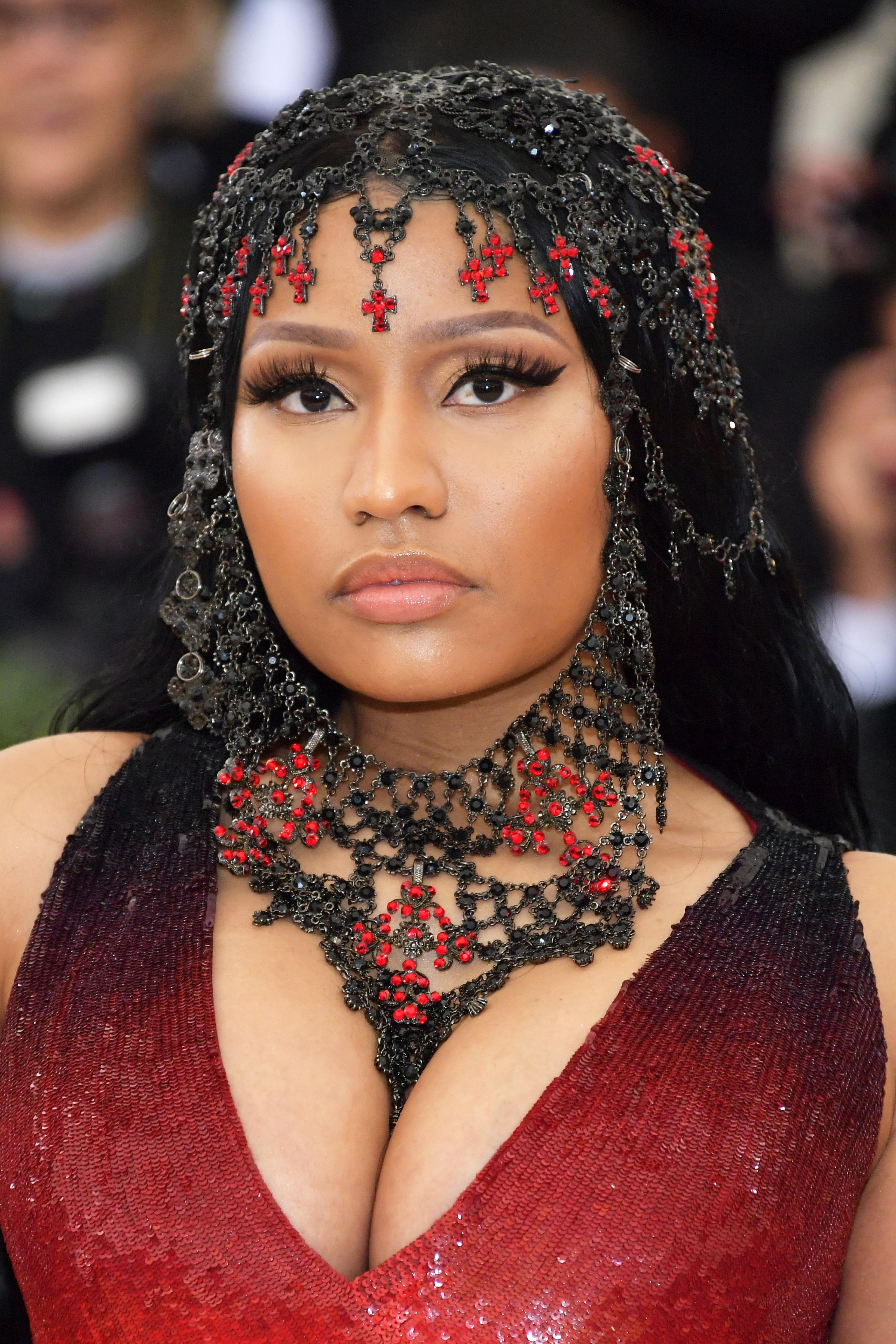 Close-up of Nicki at a media event in a deep_V outfit and ornate headgear