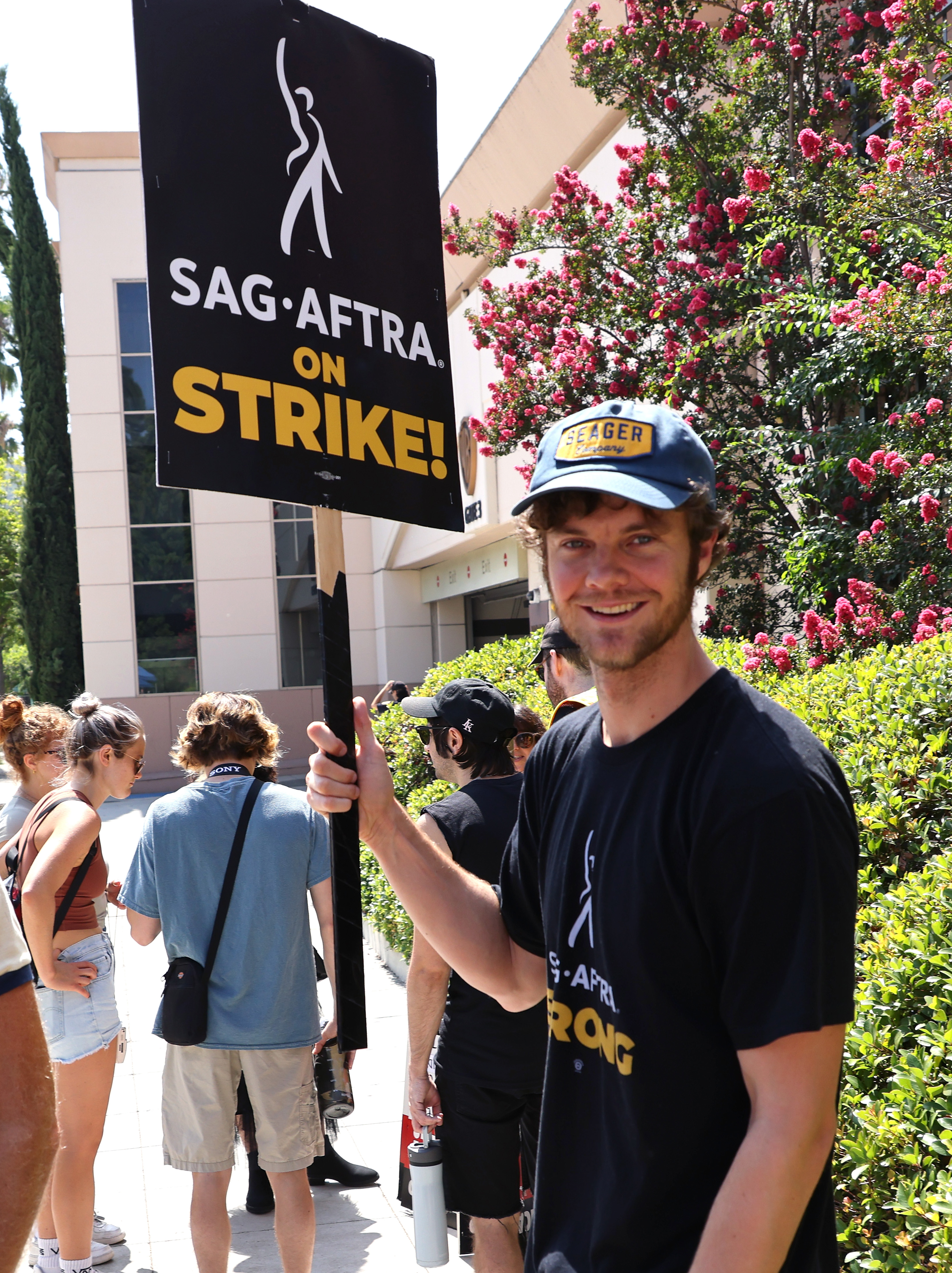 Jack smiling and holding up a picket sign