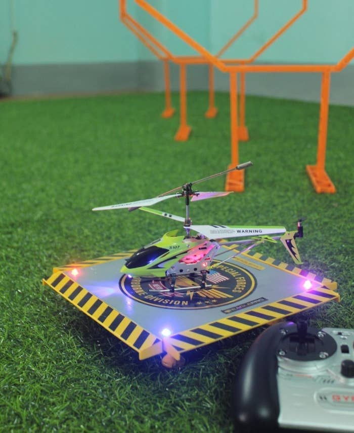 green remote-control helicopter on light-up pad