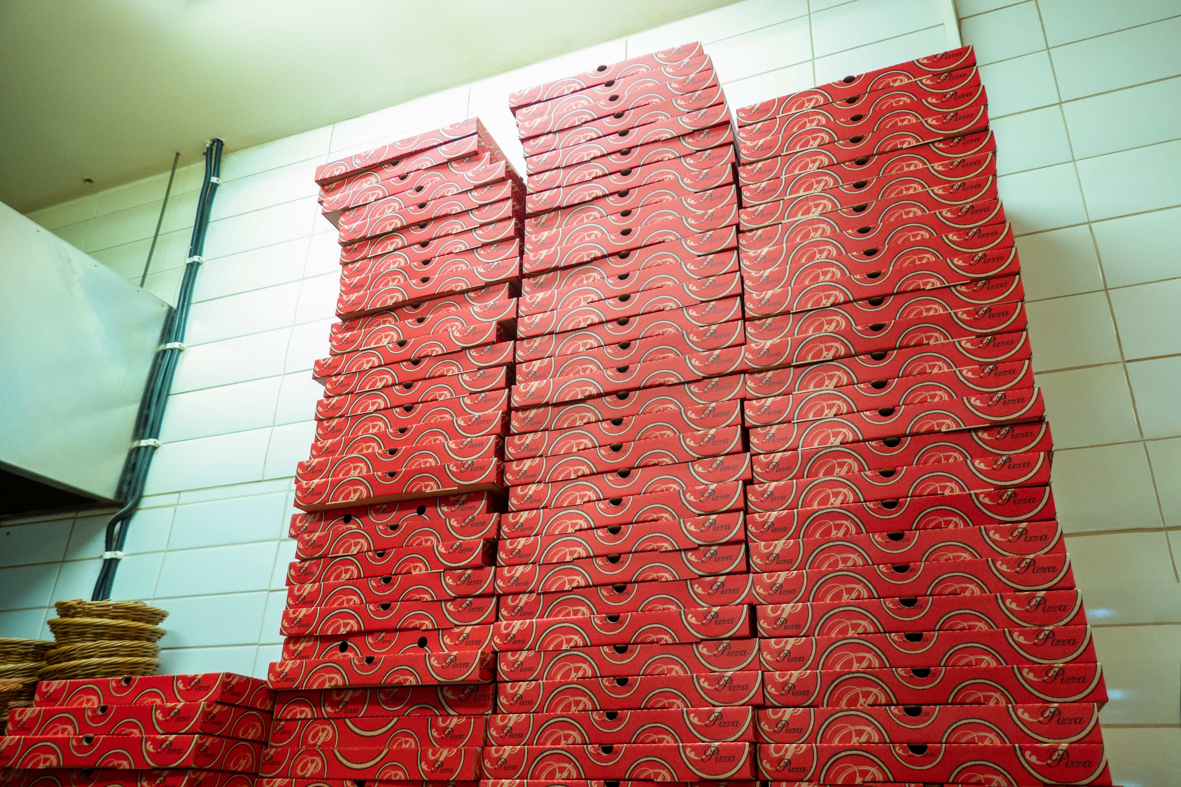 Pizza boxes stacked in the back of a pizzeria