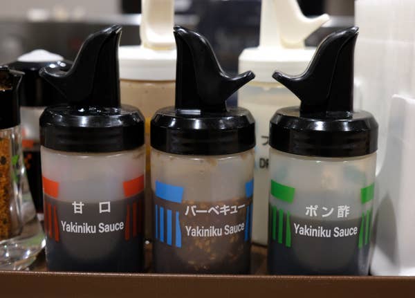 松屋にある調味料ボトル。「甘口」「バーベーキュー」「ポン酢」の全ての英文表記が「Yakiniku Sauce」となっている（都内で撮影）