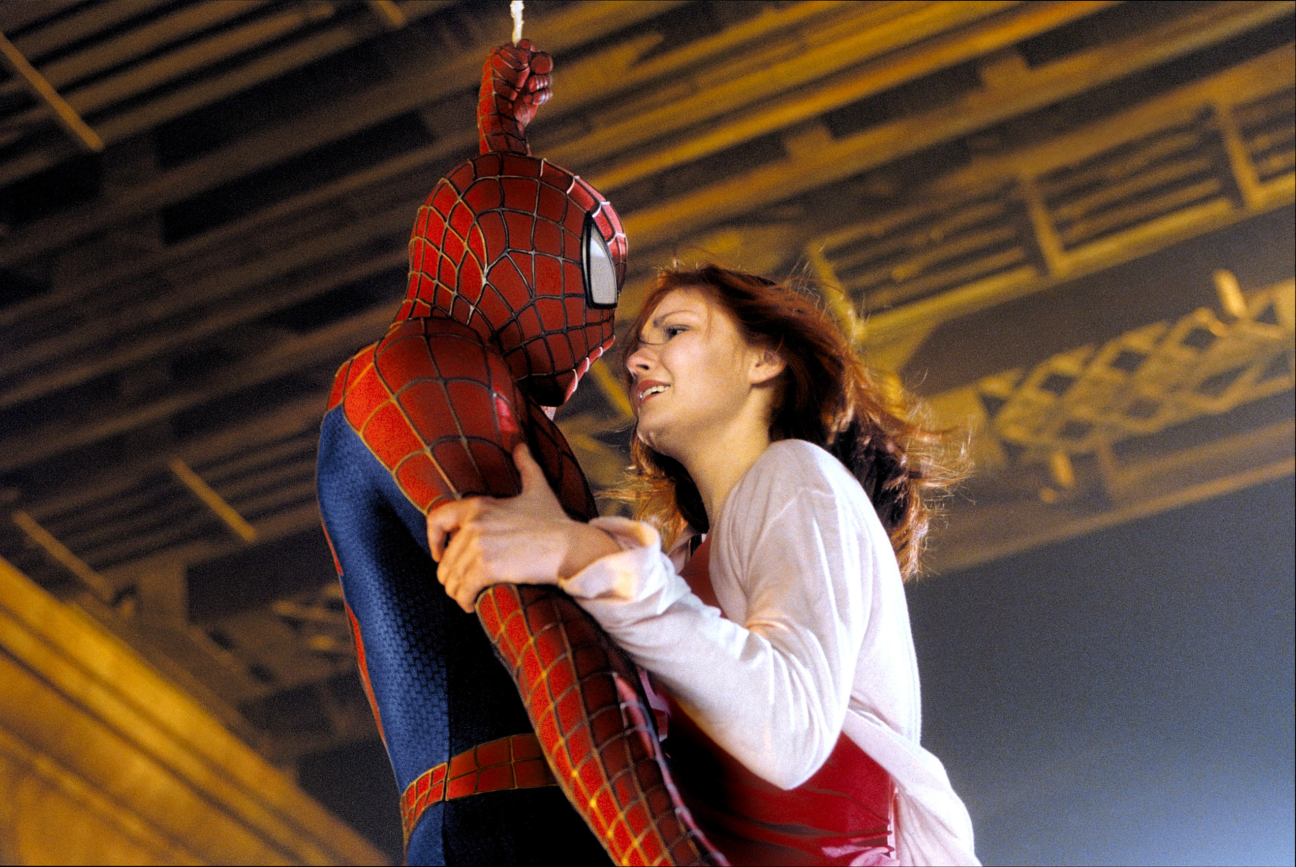 she clings to spider-man as they hang from a building