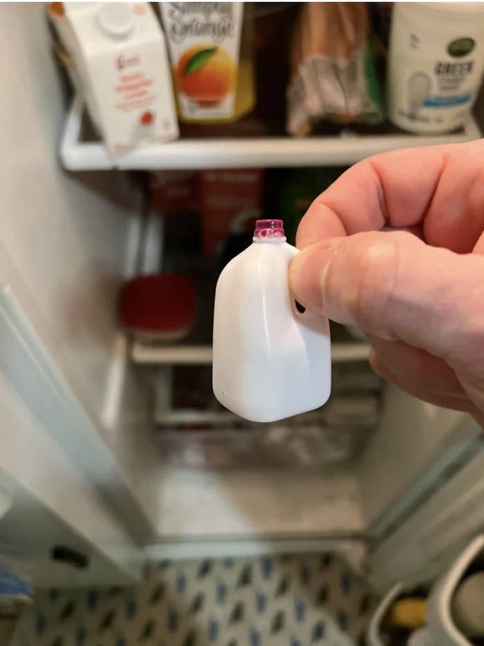 A hand holding a tiny milk