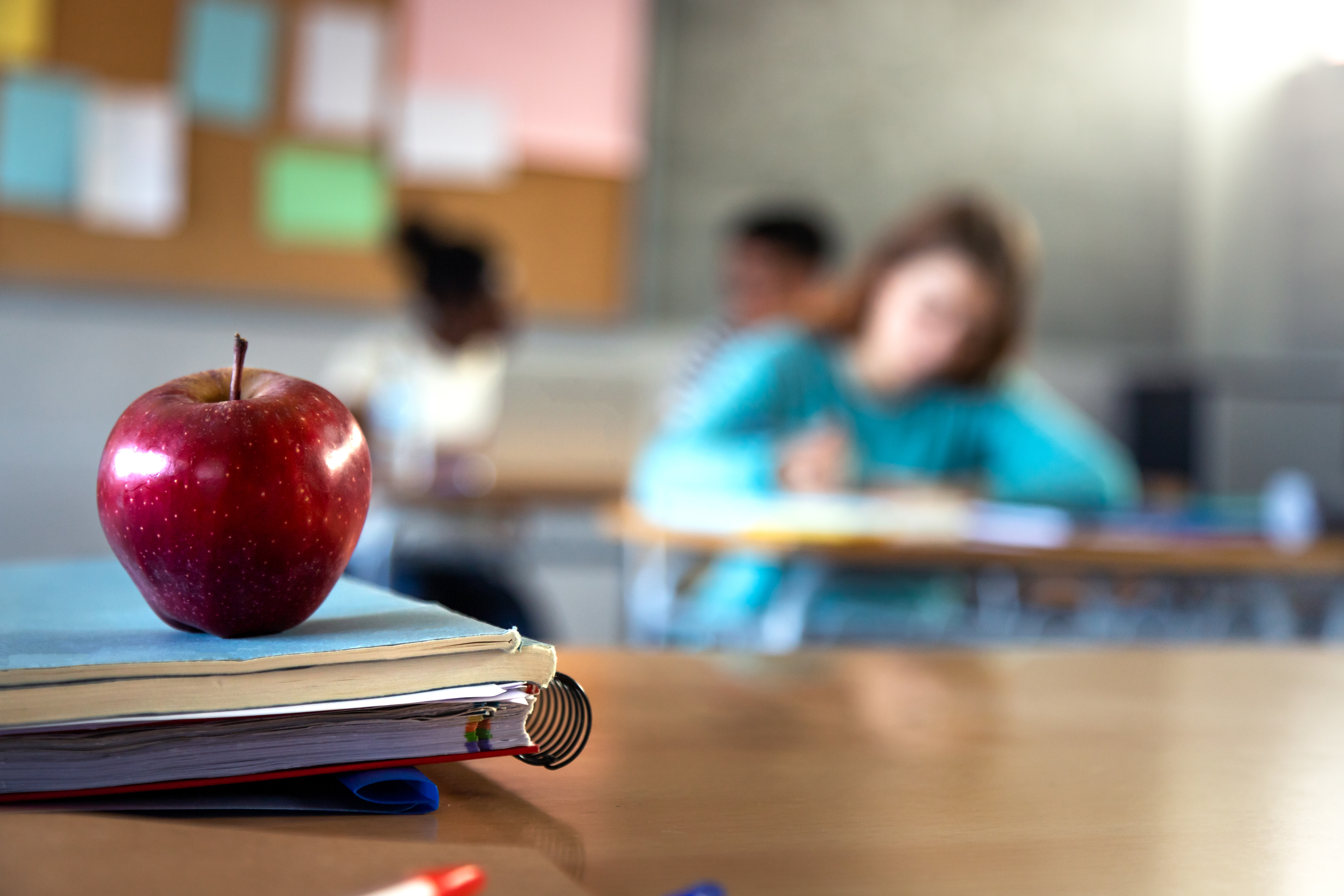 an apple on a teacher desk