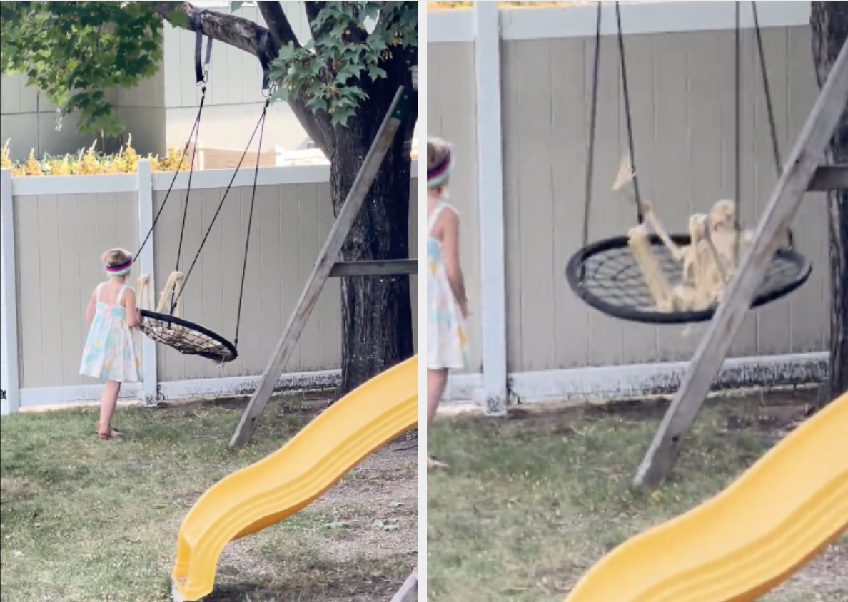 a little girl pushing a skeleton on a swing
