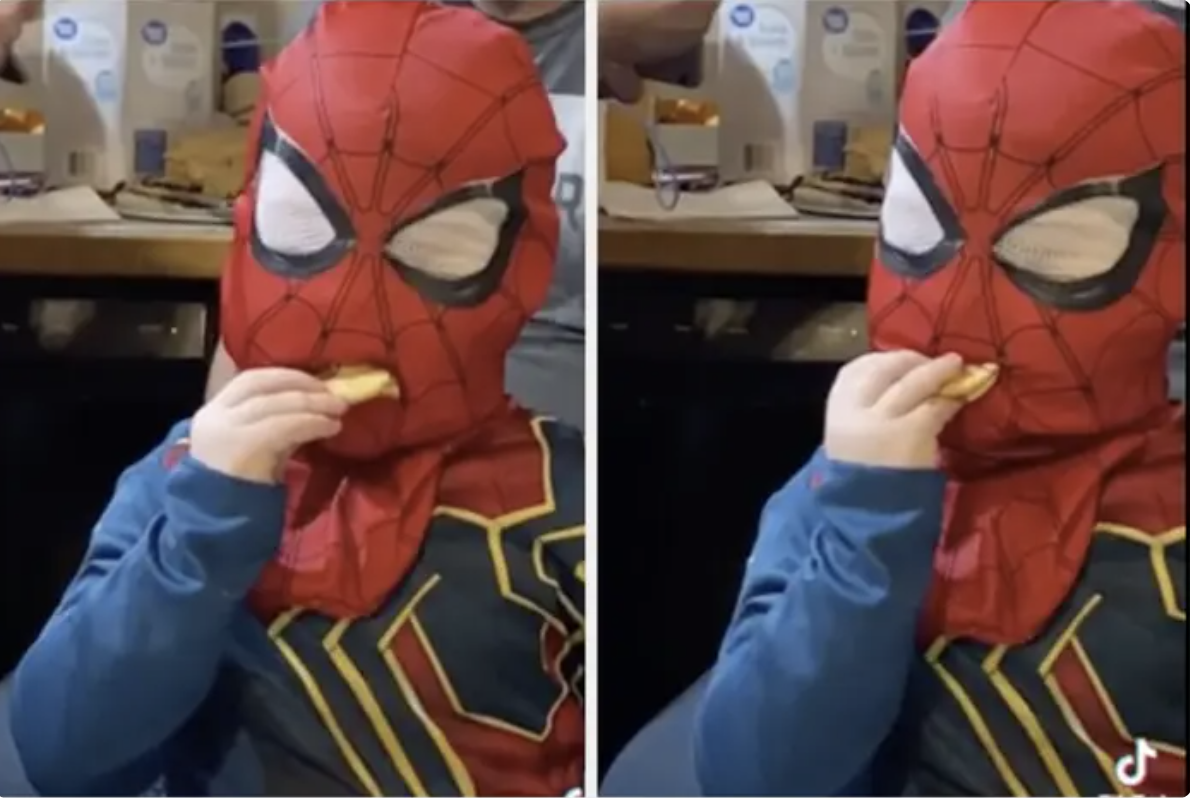 a kid trying to eat through his Spider-Man mask