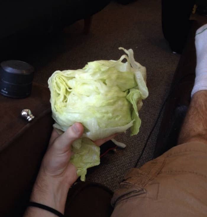 A man is eating a head of lettuce