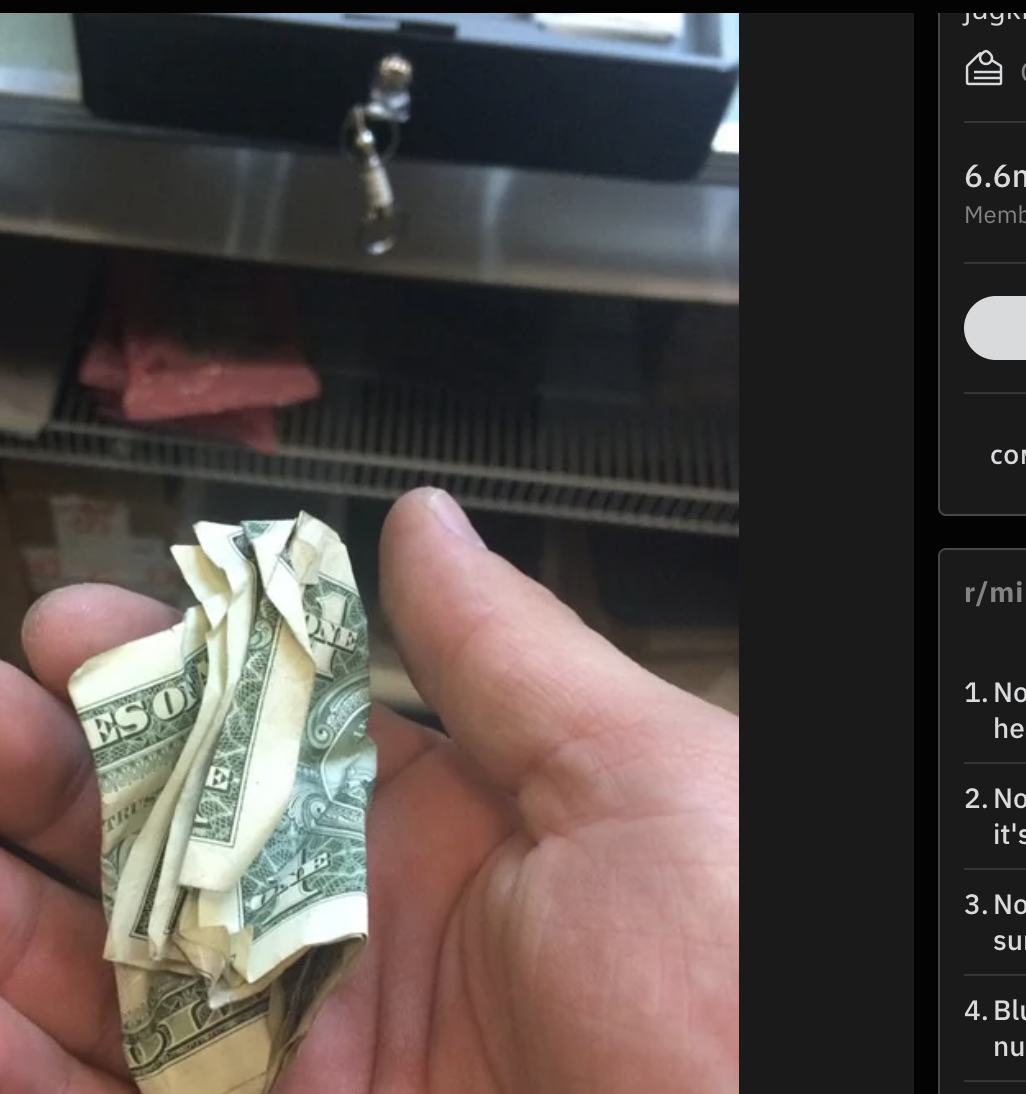 A cashier is holding crumpled money