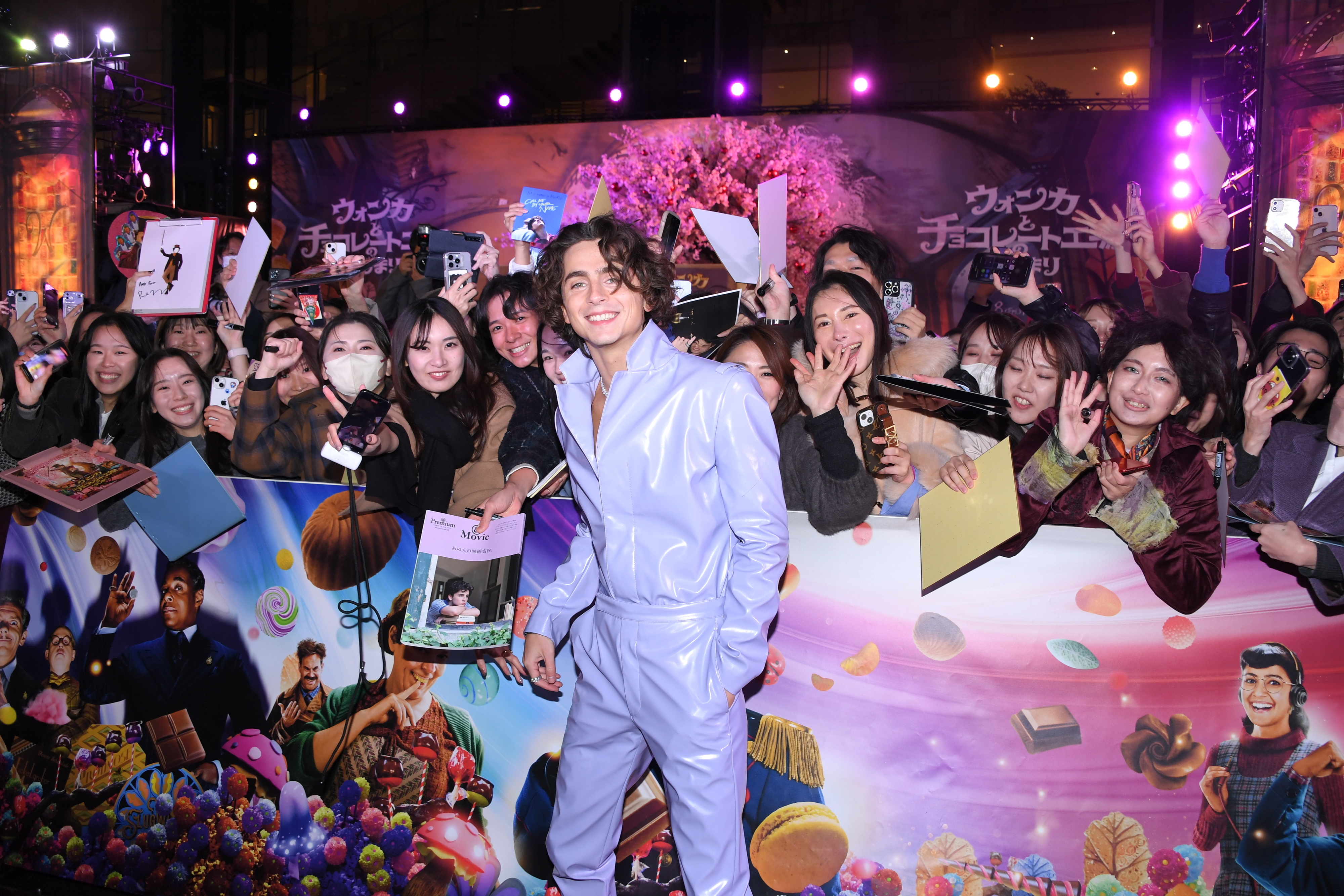 Timmy in a lavender plasticky suit in front of fans