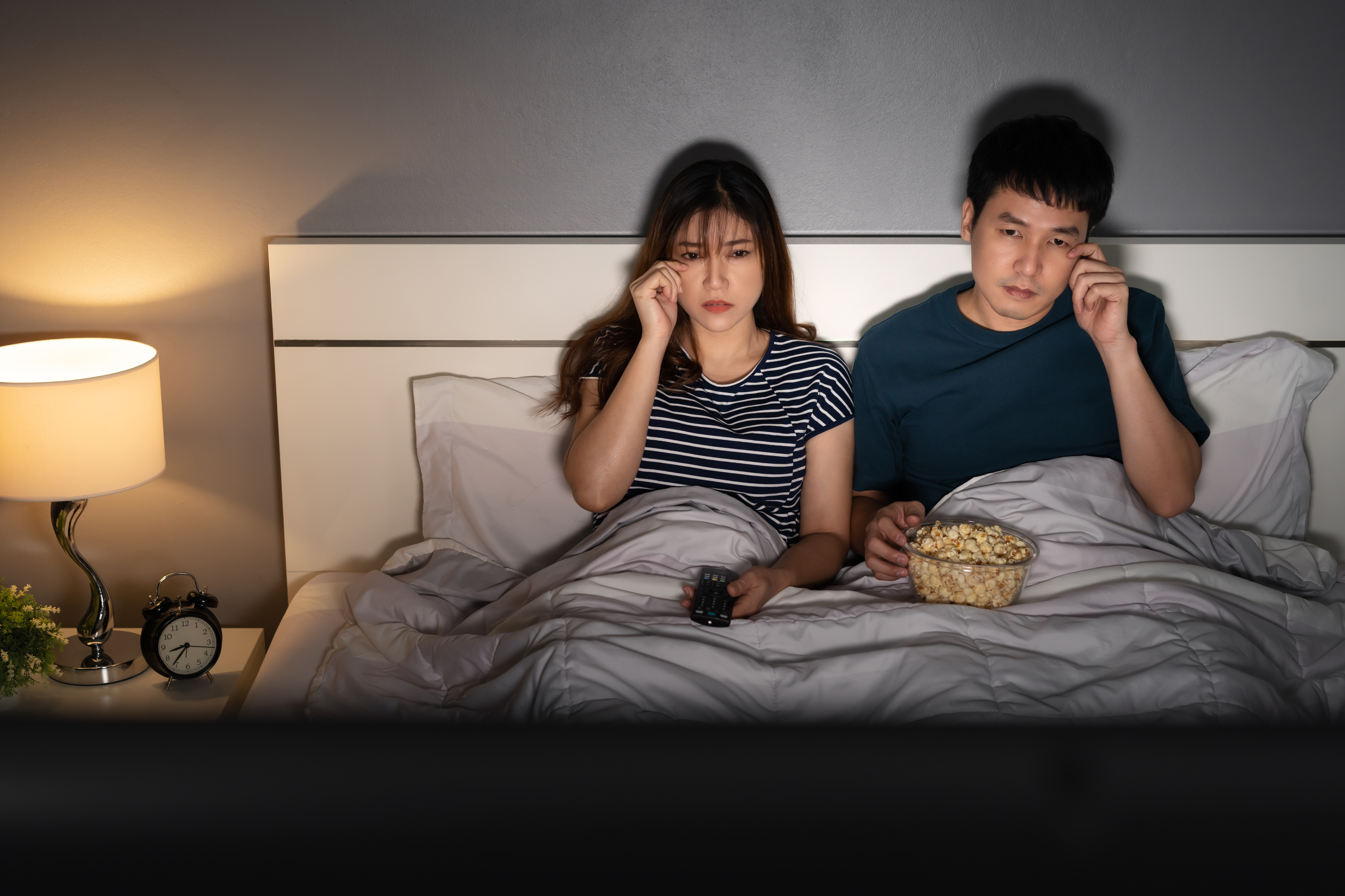 couple watching TV in bed together
