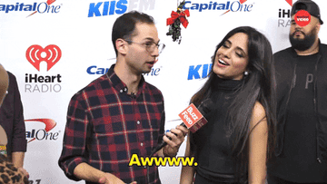 An interviewer and Camila Cabello under a mistletoe.