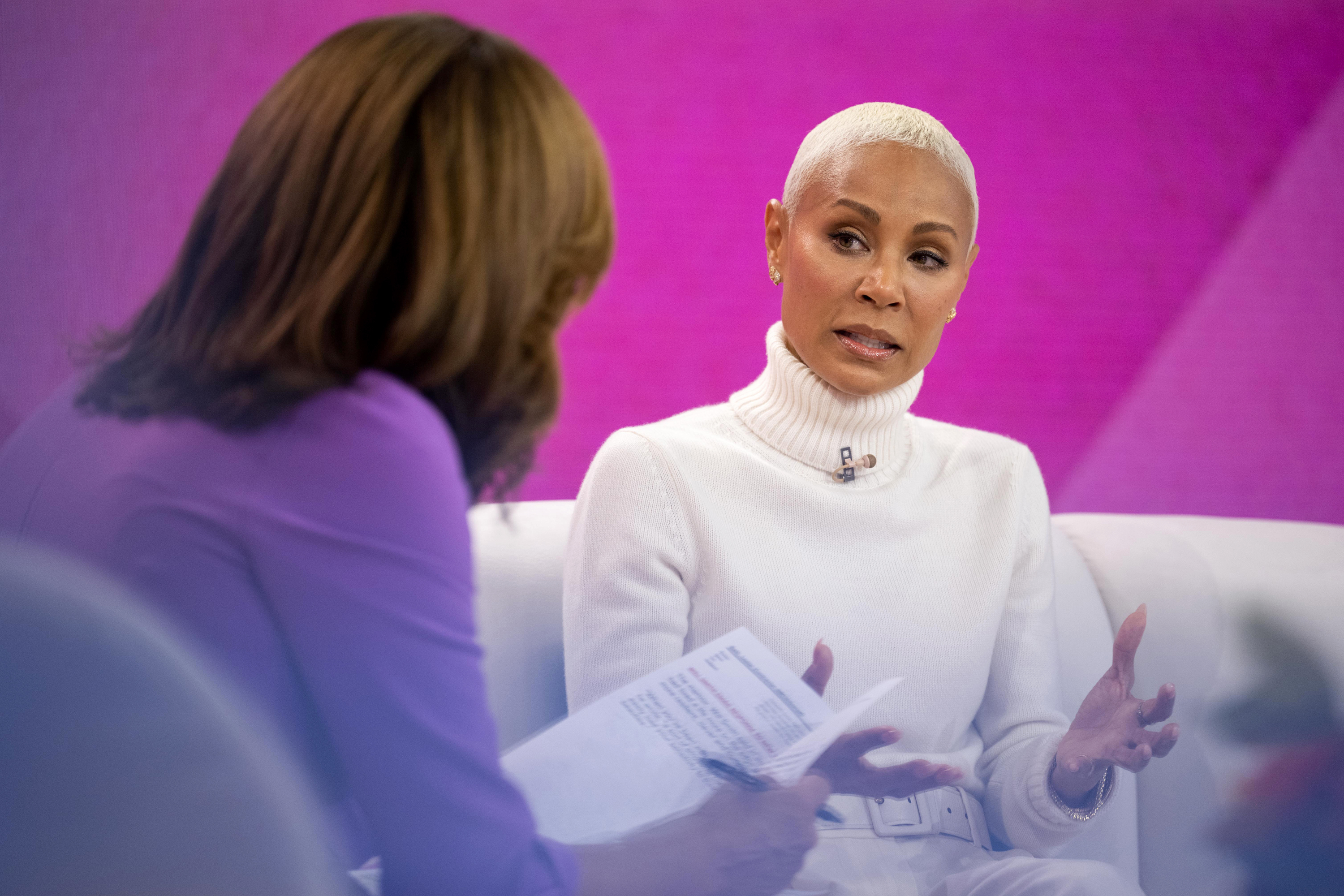 Close-up of Jada sitting on a couch and being interviewed