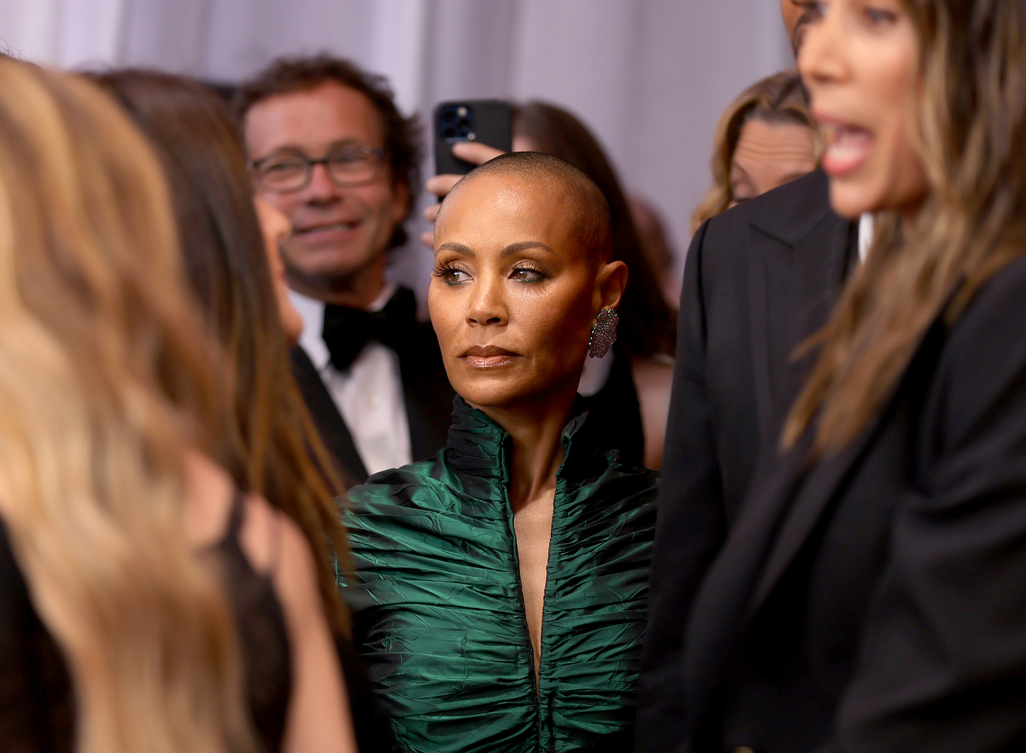 Close-up of Jada in a crowd, looking serious