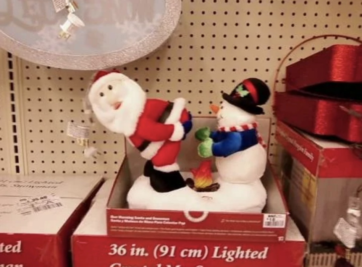 Santa bending over in front of a snowman