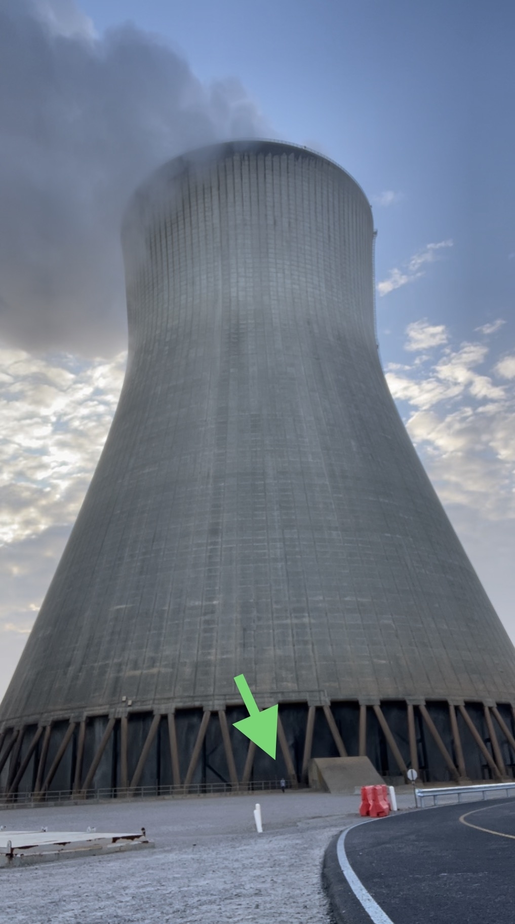 a person standing next to a nuclear cooling tower