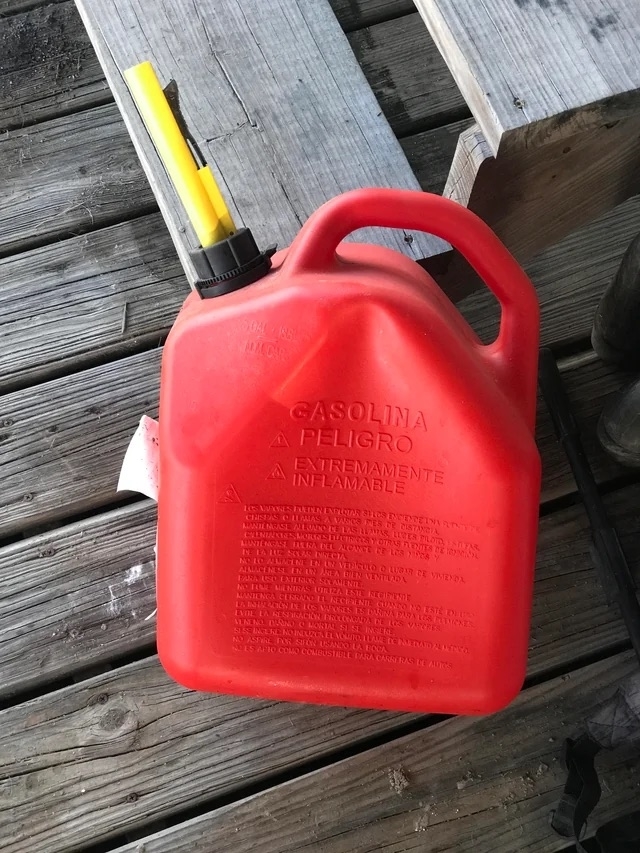 a plastic red gas can with a safety nozzle