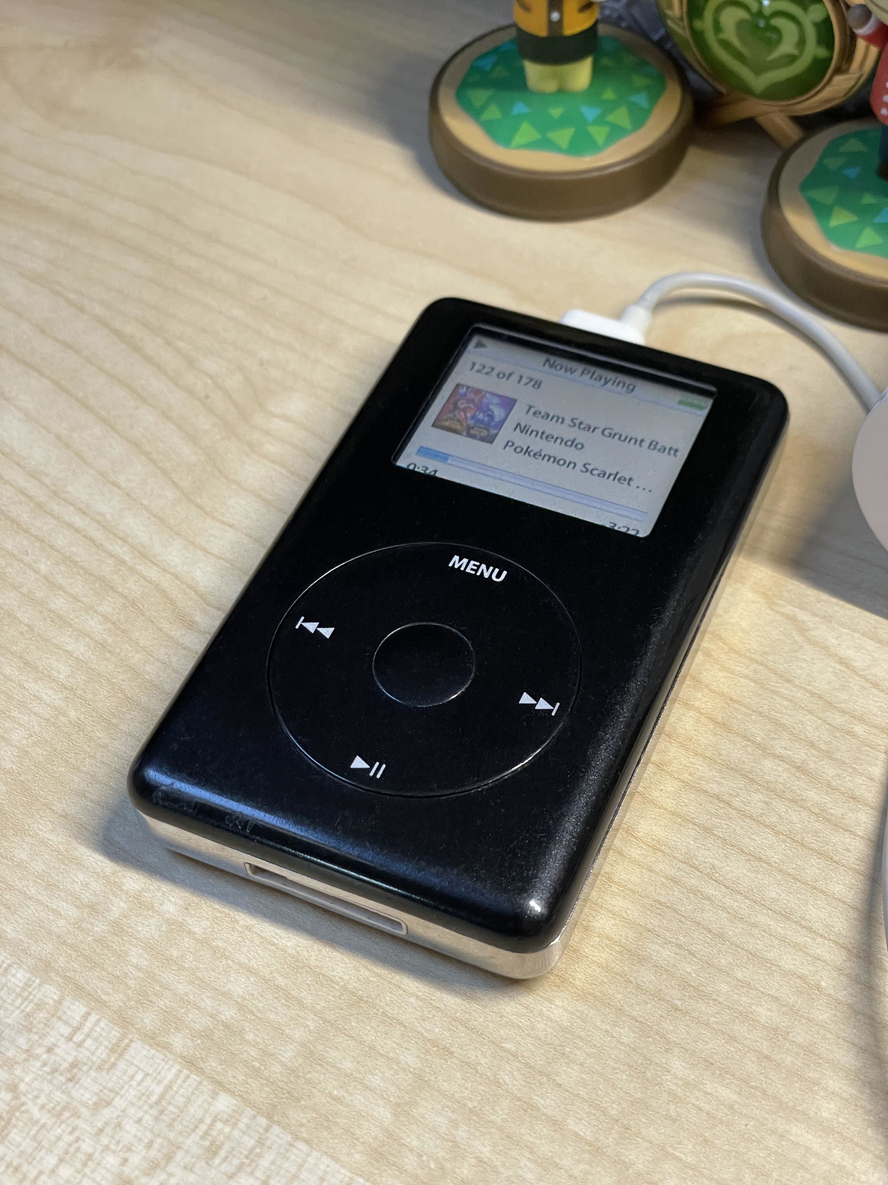 a black 4th generation ipod being charged