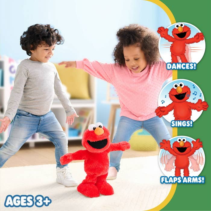 Two kids dancing behind Elmo