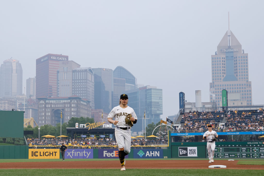 Pittsburgh Pirates center fielder Jack Suwinski (65) and right fielder Henry Davis (32) jog off the field in between innings as wildfire smoke from wildfires in Central Canada descends on the downtown skyline