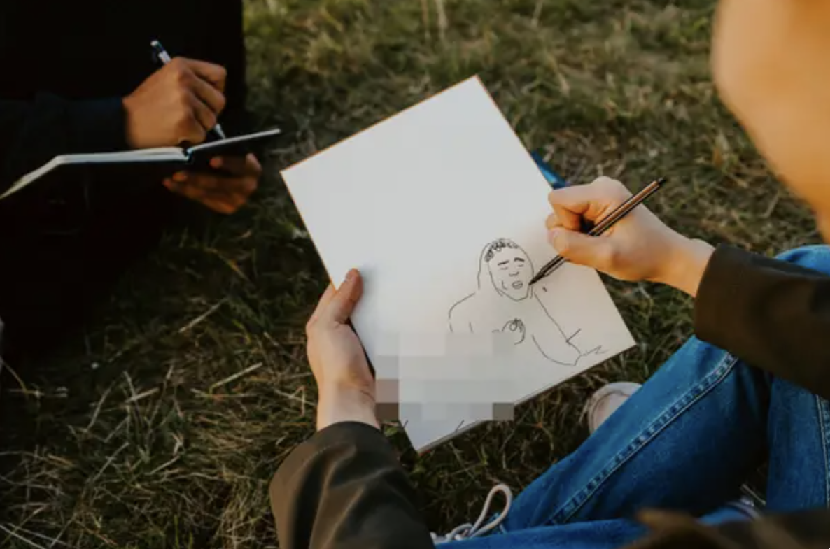 A person is drawing a man in his sketchpad
