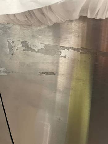 A reviewer's stainless fridge before: marred by by lots of duct tape residue