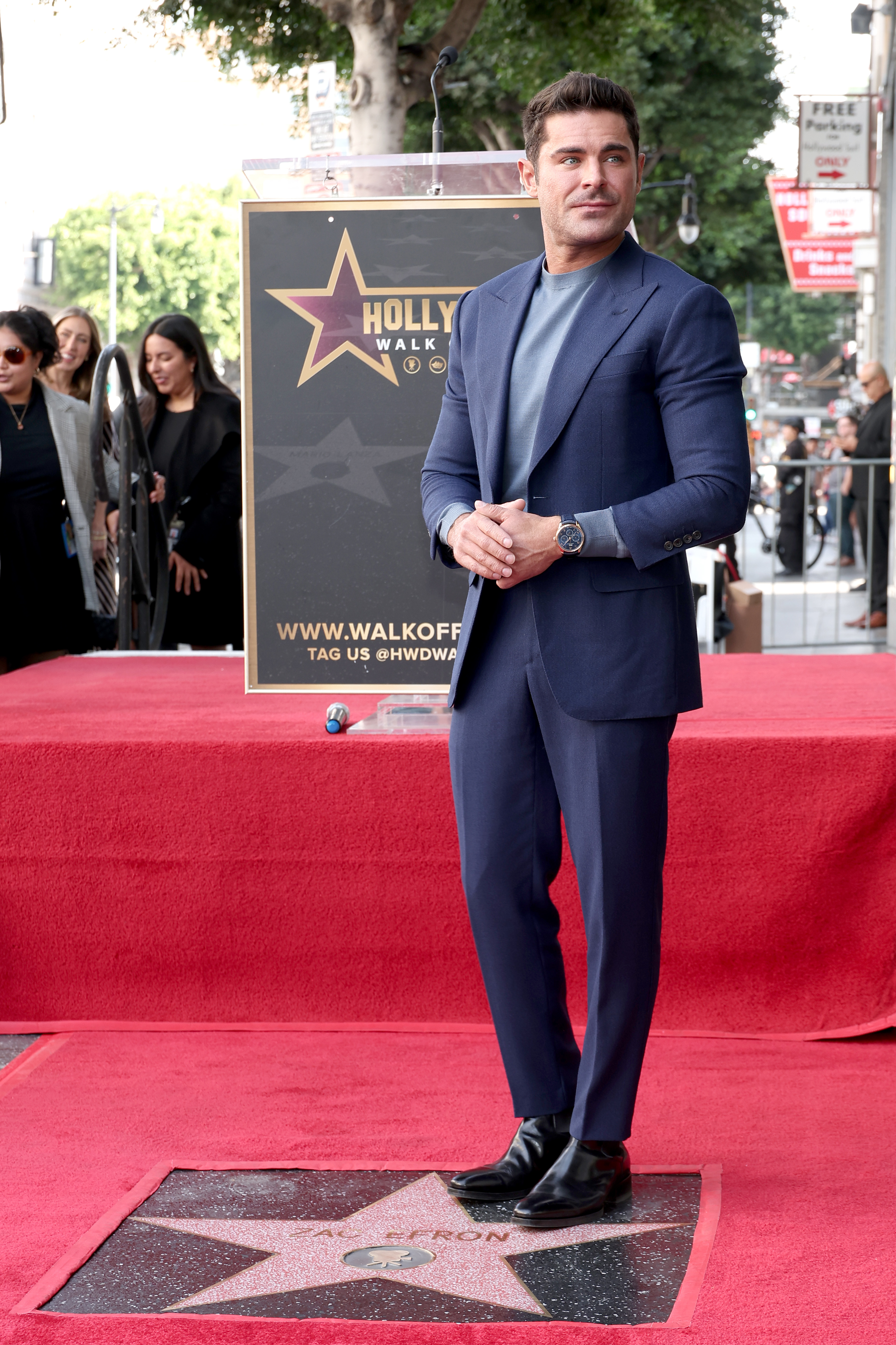 Closeup of Zac Efron standing next to his star