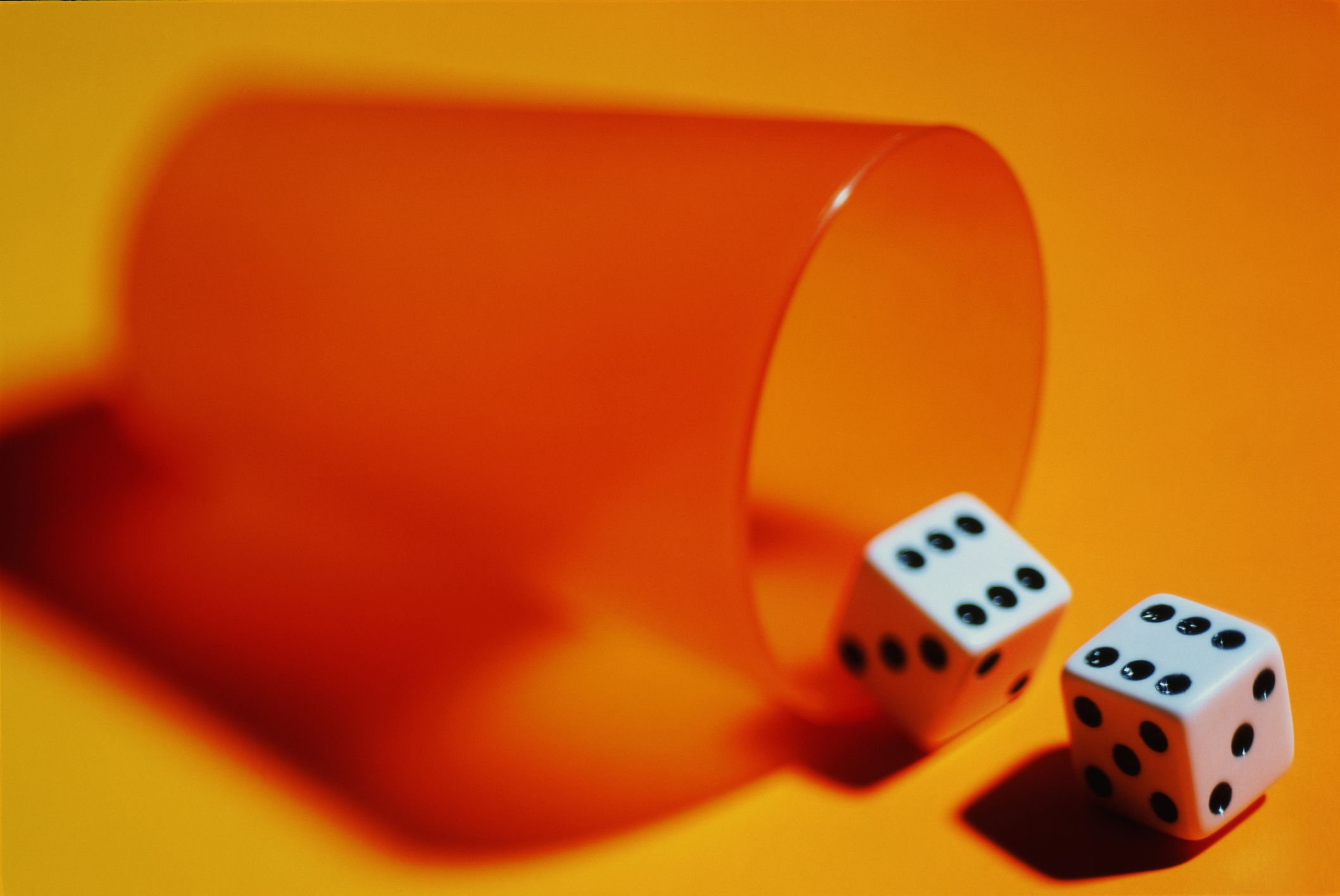 a cup tipped over with dice falling out