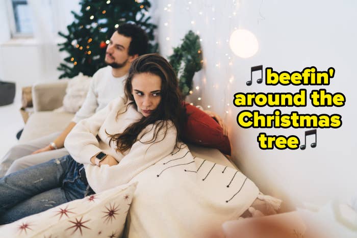 text over an unhappy couple on a couch that says beefin around the christmas tree