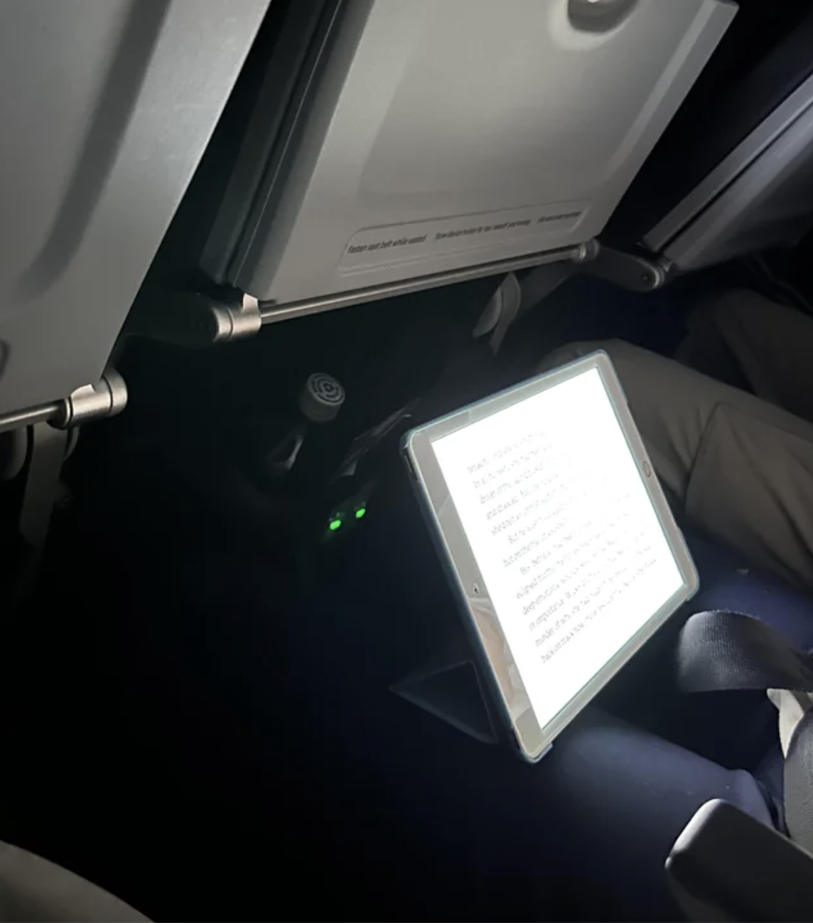 a person&#x27;s bright iPad on a plane