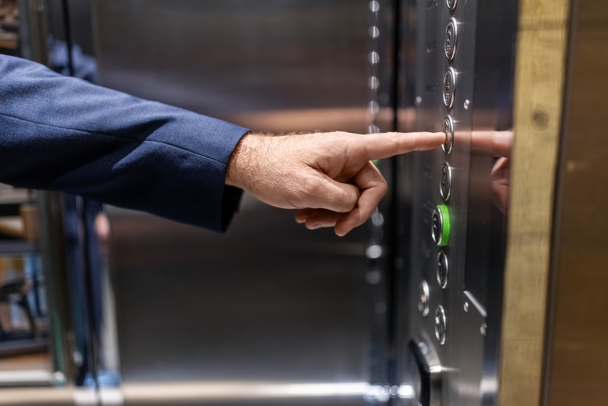 a person pressing a button on an elevator