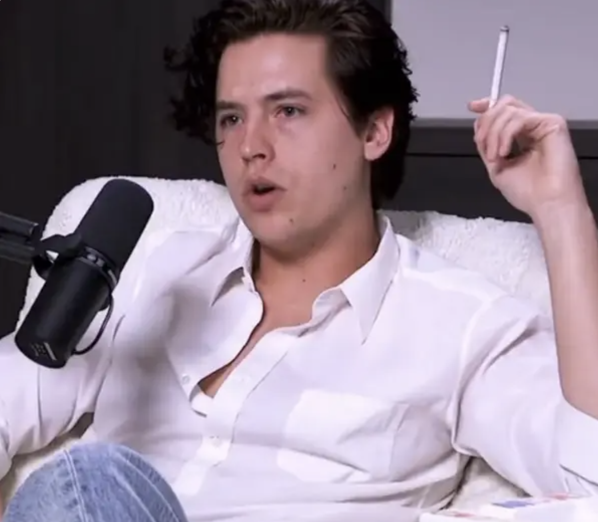 Closeup of Cole Sprouse with a cigarette in his hand