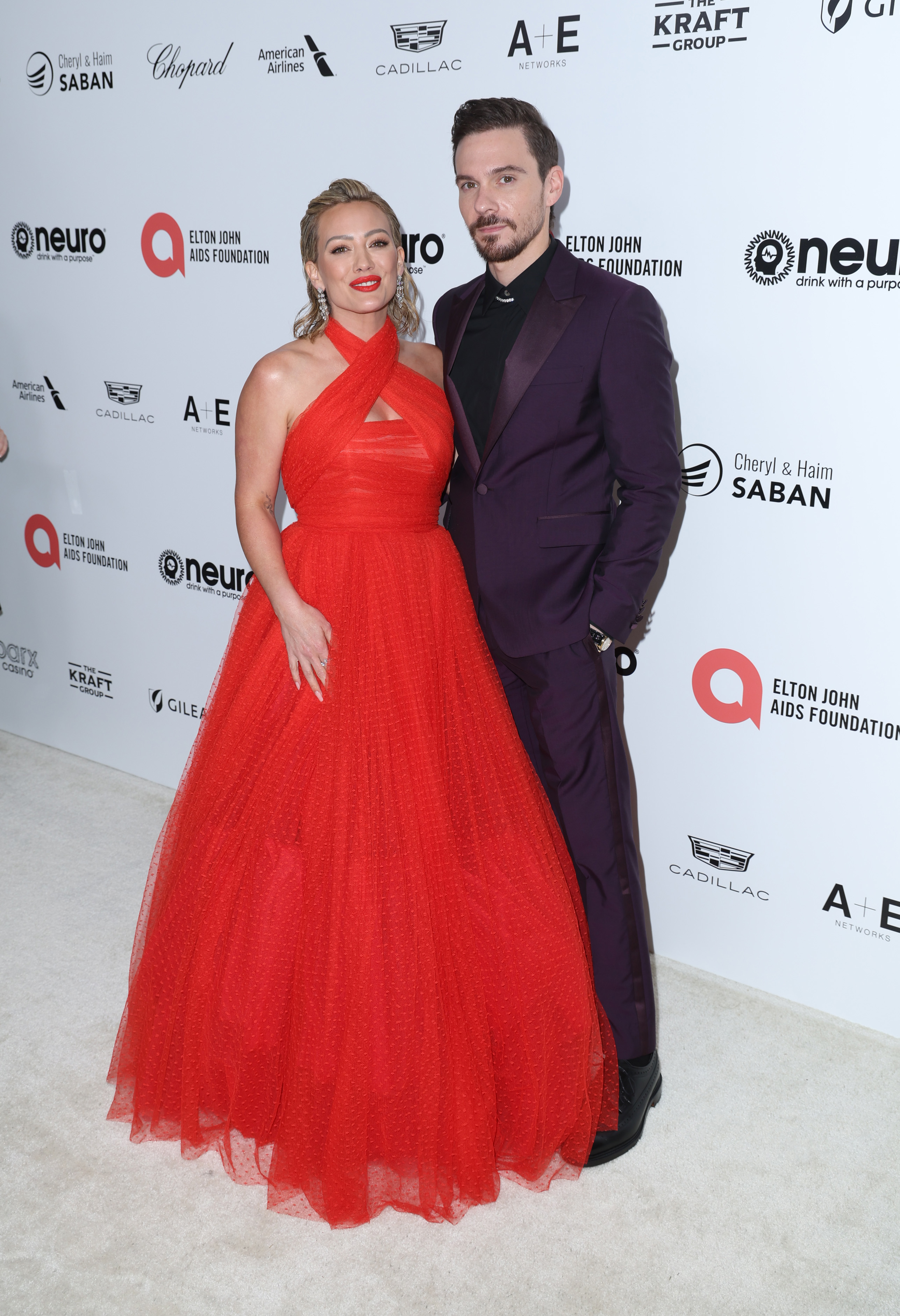 hilary wearing a tulle gown and matthew in a suit for an event