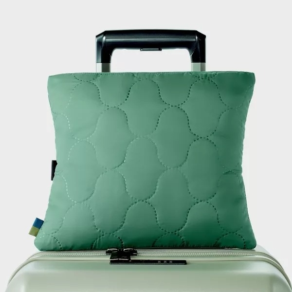 travel blanket folded up into a pillow in color green