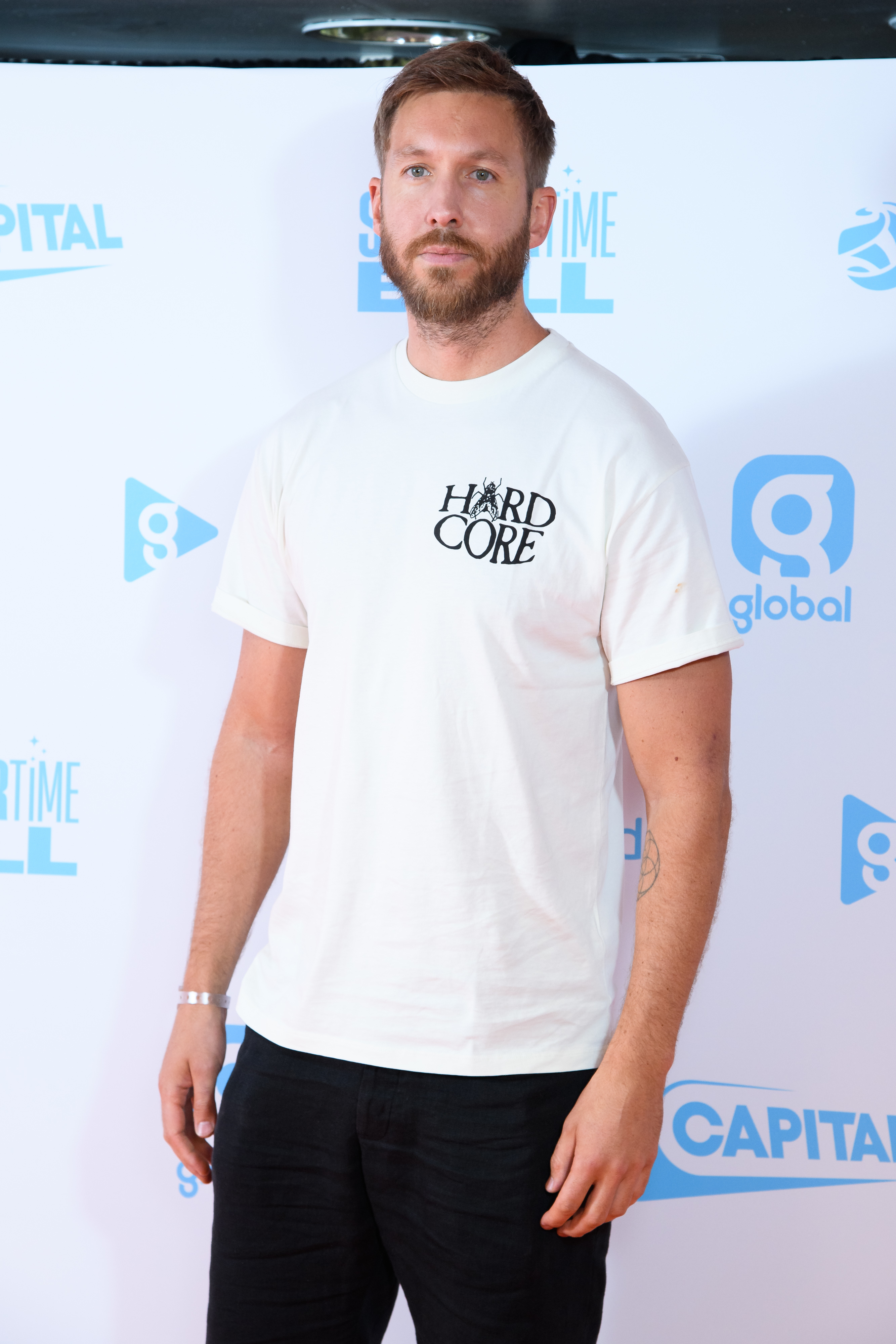 Close-up of Calvin at a media event wearing a short-sleeved T-shirt and pants