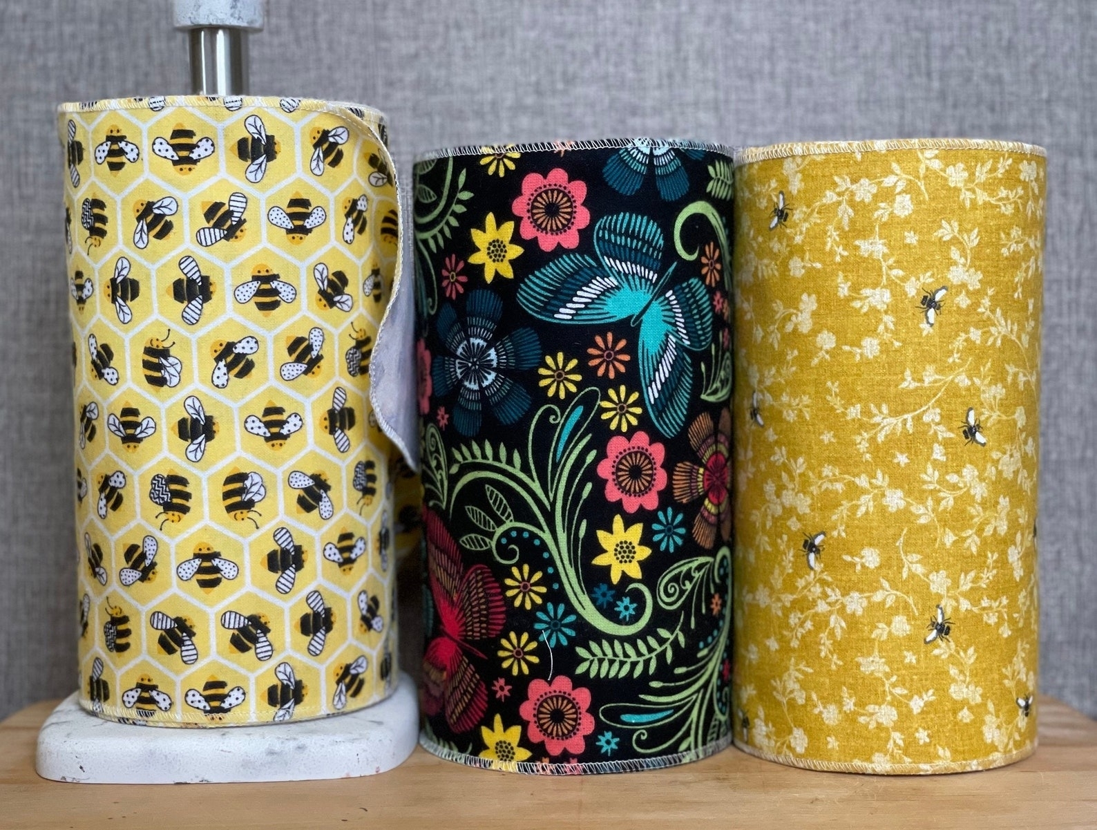 three handmade reusable towel rolls with three different designs