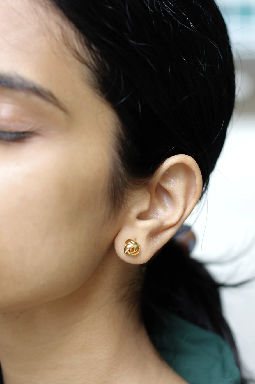Model wearing gold rose earrings