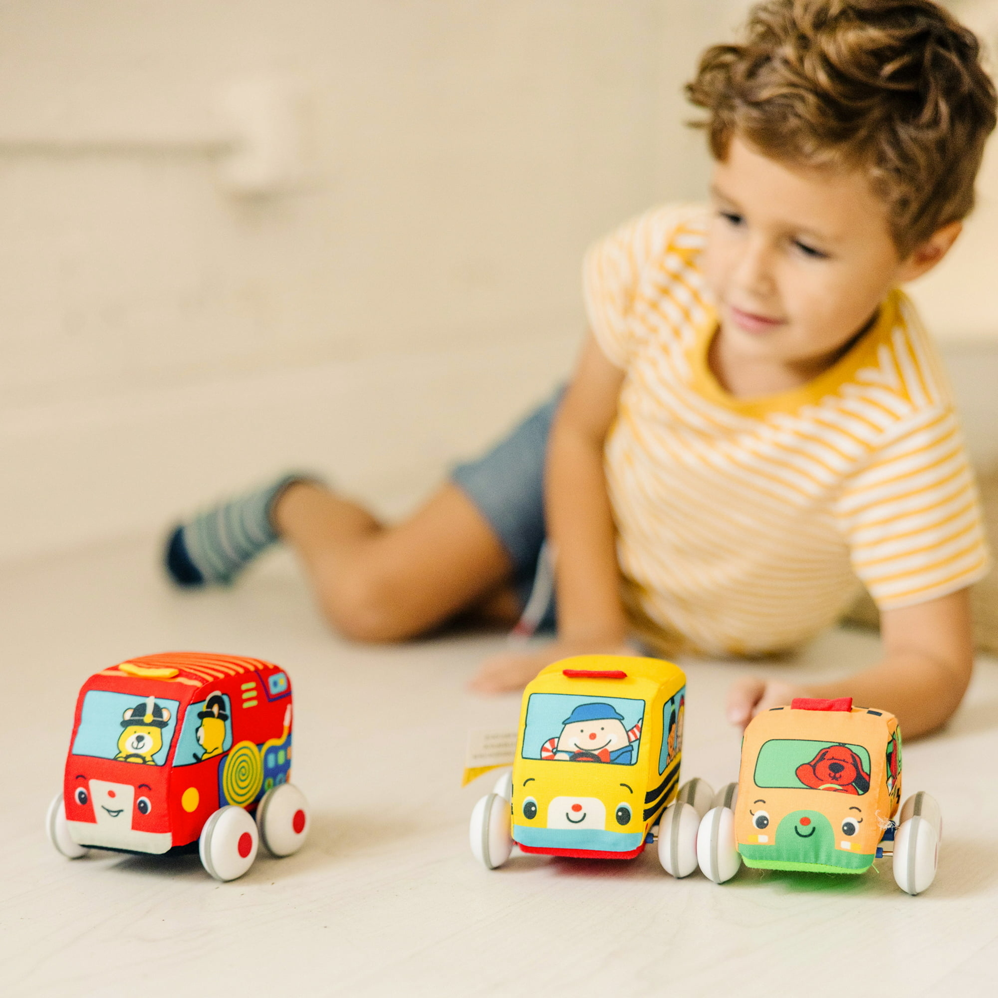 boy playing with three cars
