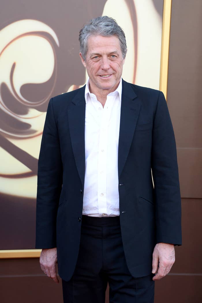 Hugh Grant at a media event in a casual suit