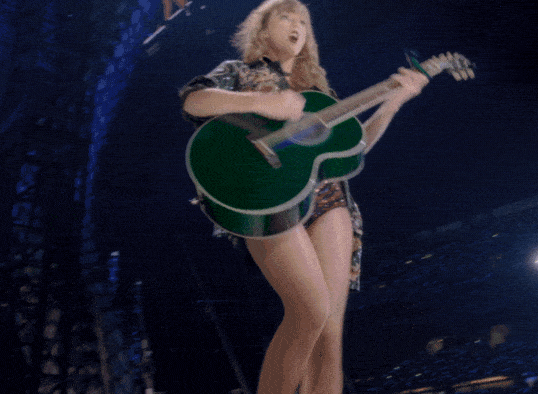 Taylor Swift performs with a green guitar on the Reputation Stadium Tour.