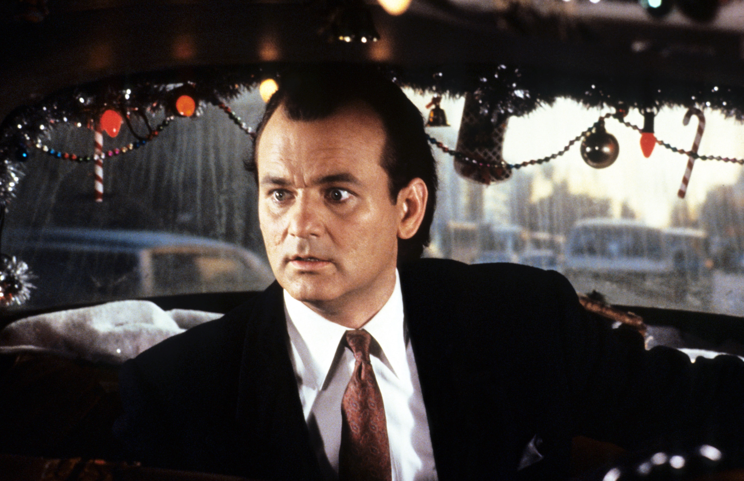 bill murray sitting in the back of a christmas decorated cab