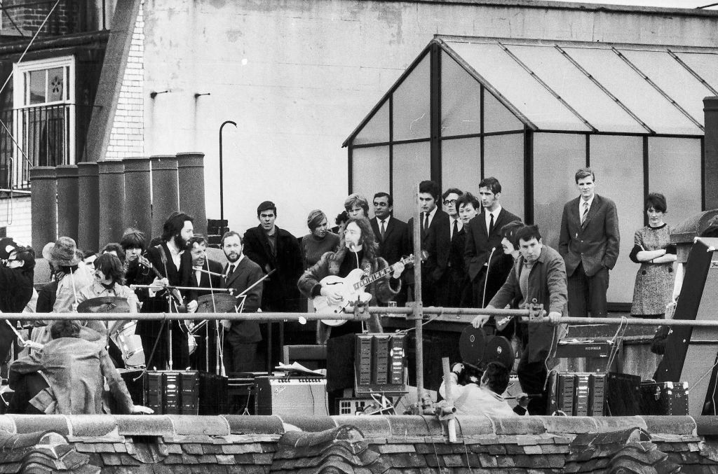 The Beatles performing on the roof of a building