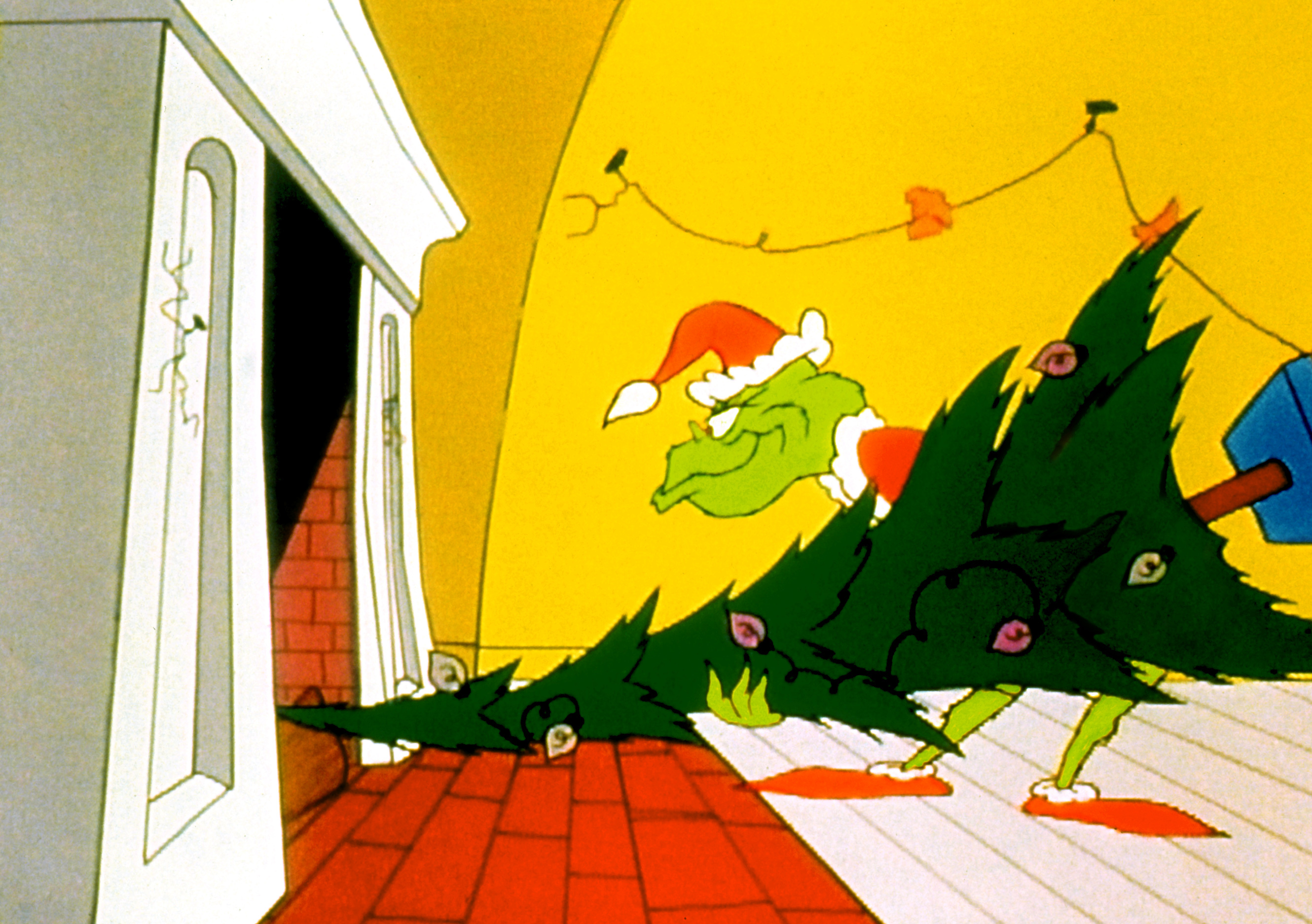 The grinch in a santa outfit shoving a christmas tree into the fireplace and up the chimney