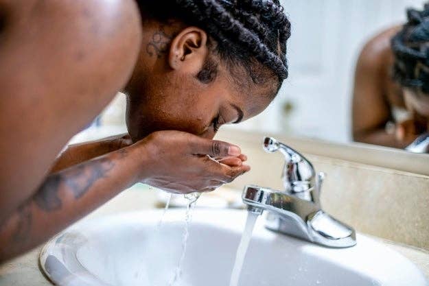 woman washing face at sink