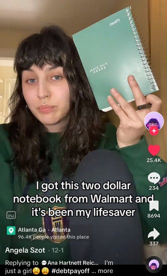 Angela holding up her $2 notebook from Walmart