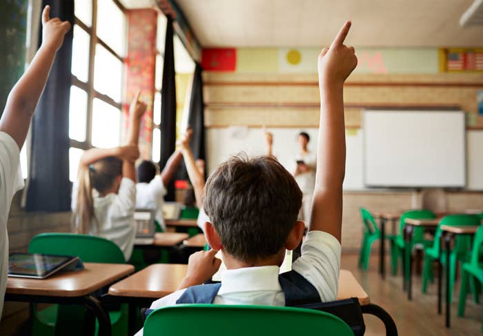 Kids raising their hands in class